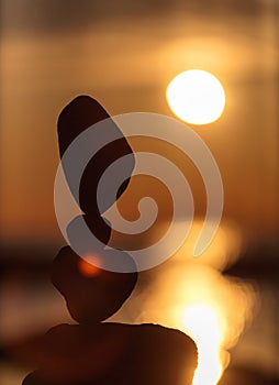 Balanced stones on the beach at sunset