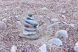 Balanced stones on sea beach. Sand on beach. Pyramid of pebbles. Harmony, balance and relax concept