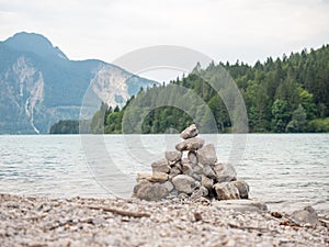 Balanced stones stacked in pyramid at lake water with Dolomite Alps reflection