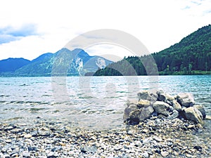 Balanced stones stacked in pyramid at lake water with Dolomite Alps reflection