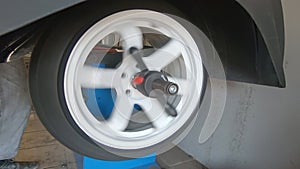 Balancing a car wheel on a special balancing stand in a tire workshop.