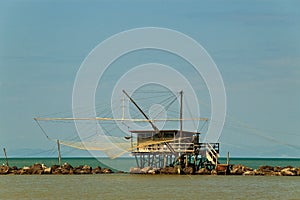 Balancing fishing hut at the river mouth photo