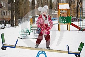 Balancing girl stand on teeter-totter photo