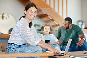 Balancing her responsibilities as mom and entrepreneur. Portrait of a mother using a laptop while her husband takes care