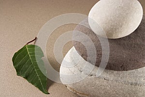 Balancing pebbles with a green leave