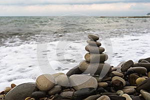 Balancing pyramid of sea stones on a pebble beach