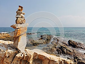 Balancing stones with each other on a rocky sea shore.