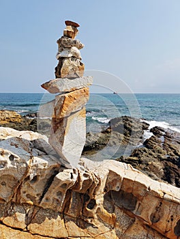 Balancing stones on a rocky sea shore