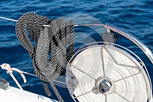 Balck mooring lines hanging on the reeling on a sailing yacht