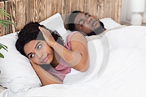 Balck woman suffering from her snoring boyfriend