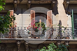 Balconies with flowers of the one of old buildings in modern style in the historical center of Barcelona in sunny day. Spain