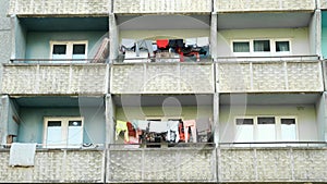 Balconies of panel building in ghetto with clothes hanging on ropes and drying.