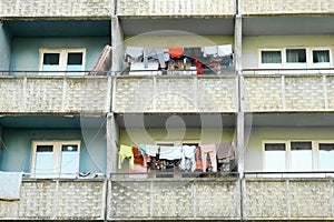 Balconies of panel building in ghetto with clothes hanging on ropes and drying.