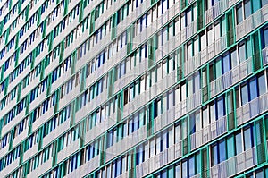 Balconies and windows of a building, apartment houses textured beige green lattices.