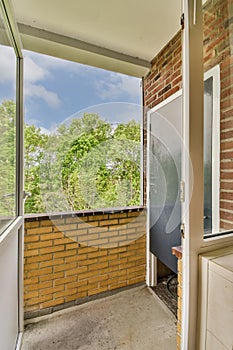 a balcony with a brick wall and a glass door