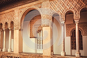 Balcony with carvings and arches inside 14th century Alcazar royal palace, Mudejar architecture style, Seville