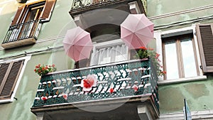 Balcony creatively adorned with umbrellas and flowers.