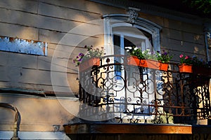 Balcony decorated with flowers on the facade of an old house.