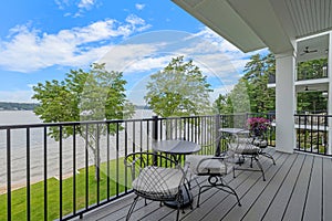the balcony on a house overlooks the river and the lawn.  in Lakeport New Hampshire