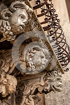 Balcony ornaments in typical Sicilian Baroque style at the Benedictine Monastery of San Nicolo l`Arena in Catania, Sicily, Italy