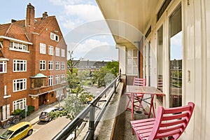 a balcony with pink chairs and a table