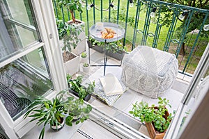 Balcony with plants, pouf a table with breakfast