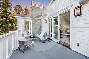 Balcony with a sofa, chairs, and an open door  in a new construction home in Encino, California