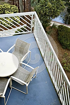 Balcony with Table and Chairs and Lush Foliage below