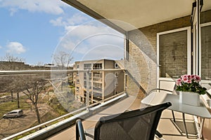 a balcony with a table and chairs and a window