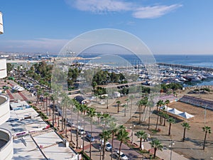 Balcony view over the Palm trees promenade and port with many boats in Larnaca town