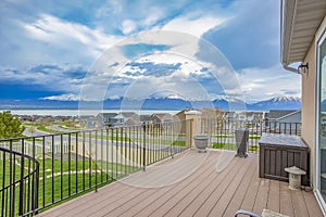 Balcony with wooden floor and metal railing overlooking lake and mountain