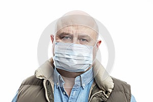 Bald adult man in a medical mask on a white background. Close-up. Precautions during the coronavirus pandemic