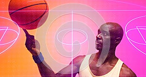 Bald african american basketball player spinning ball on finger over illuminated basketball court