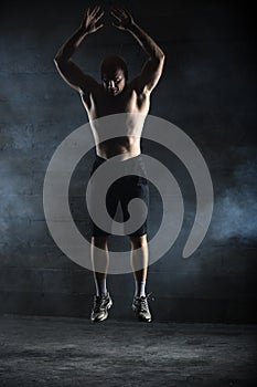 Bald athlete topless jumping up