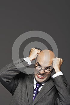 Bald Businessman With Fists Pounding Bald Head photo