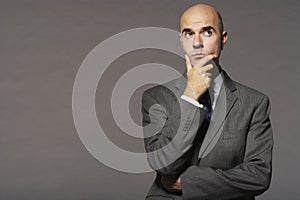 Bald Businessman With Hand On Chin Thinking