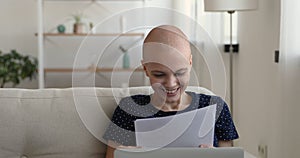 Bald after chemotherapy woman reading health test results feels happy