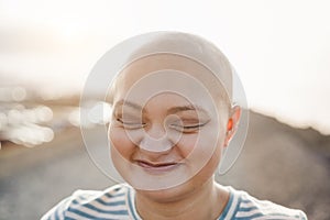 Bald girl smiling in front of camera with city on background - Focus on eyes