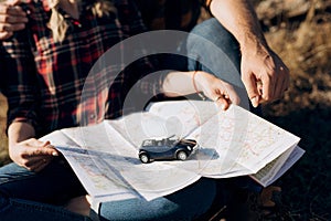 Bald guy with a beard and a blonde girl are looking at the map and looking for