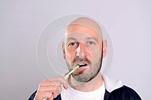 Bald headed man brushing teeth