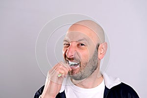 Bald headed man brushing teeth