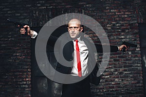 Bald hired killer in red tie aims a pistols