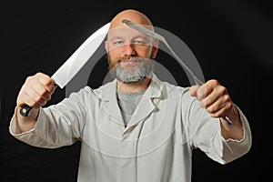 Bald male chef cook on a dark background