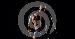 Bald male jock is wearing panties is demonstrating muscles of back, biceps, triceps