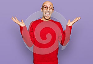 Bald man with beard wearing casual clothes and glasses celebrating victory with happy smile and winner expression with raised
