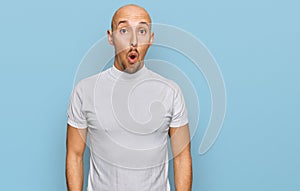 Bald man with beard wearing casual white t shirt afraid and shocked with surprise expression, fear and excited face