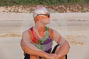 Bald man freak in bright clothes and round glasses at a freak pa