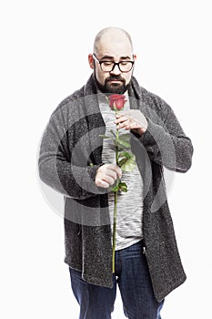 A bald man with glasses holds a red rose in his hands. White background. Vertical