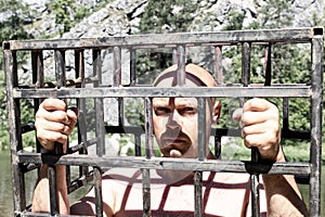 Bald man in jail or prison. Men in cage outdoor. danger or aggression conceptbald man