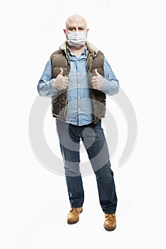 Bald man in a medical mask shows thumbs up. Precautions during the coronavirus pandemic. White background. Vertical